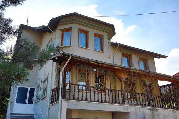 A two-story house with a balcony, a small porch, and a garage. - Kayi Apart Hotel (Bolu)