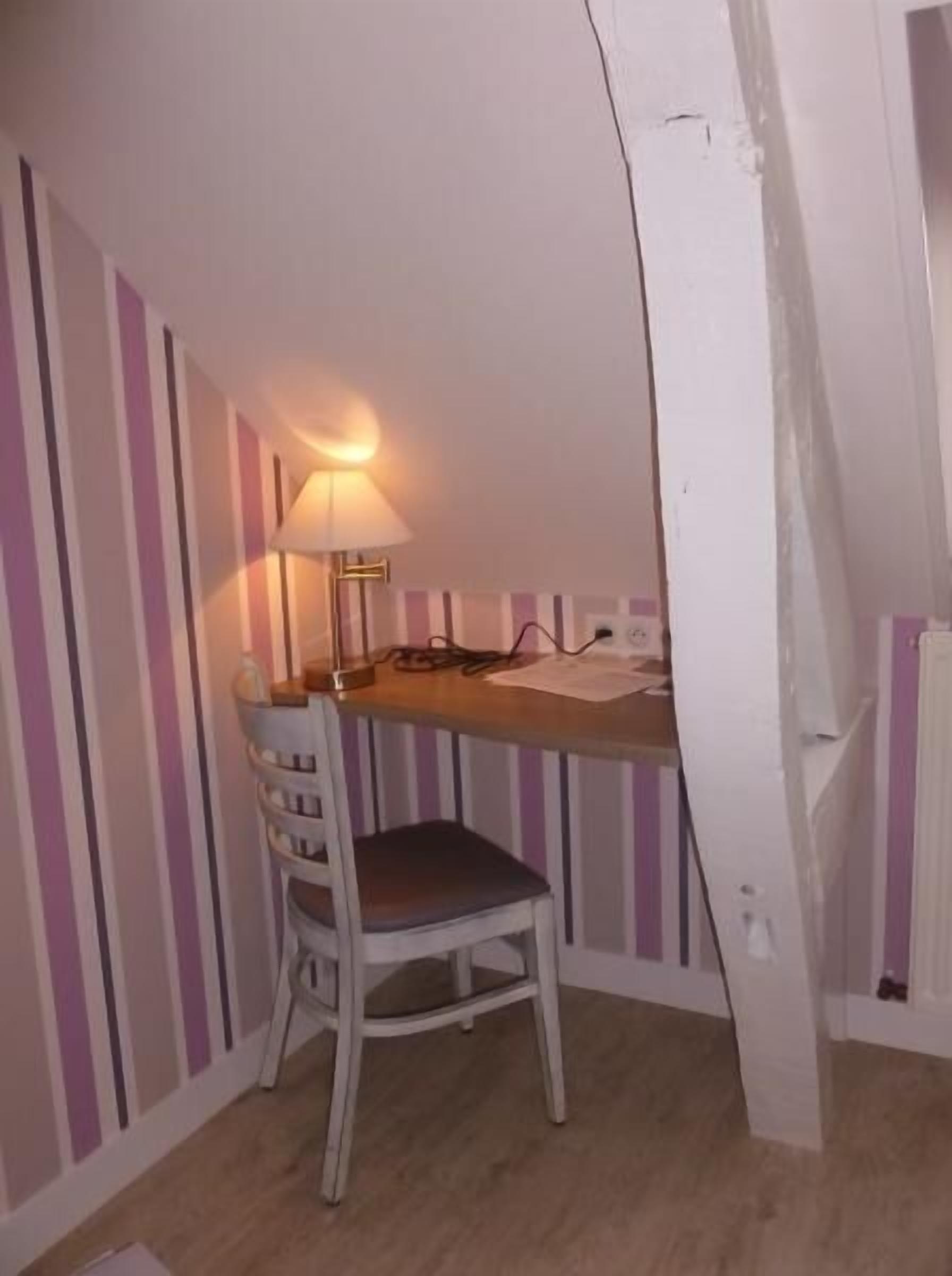 Un pequeño comedor con una mesa, una silla y una lámpara.
