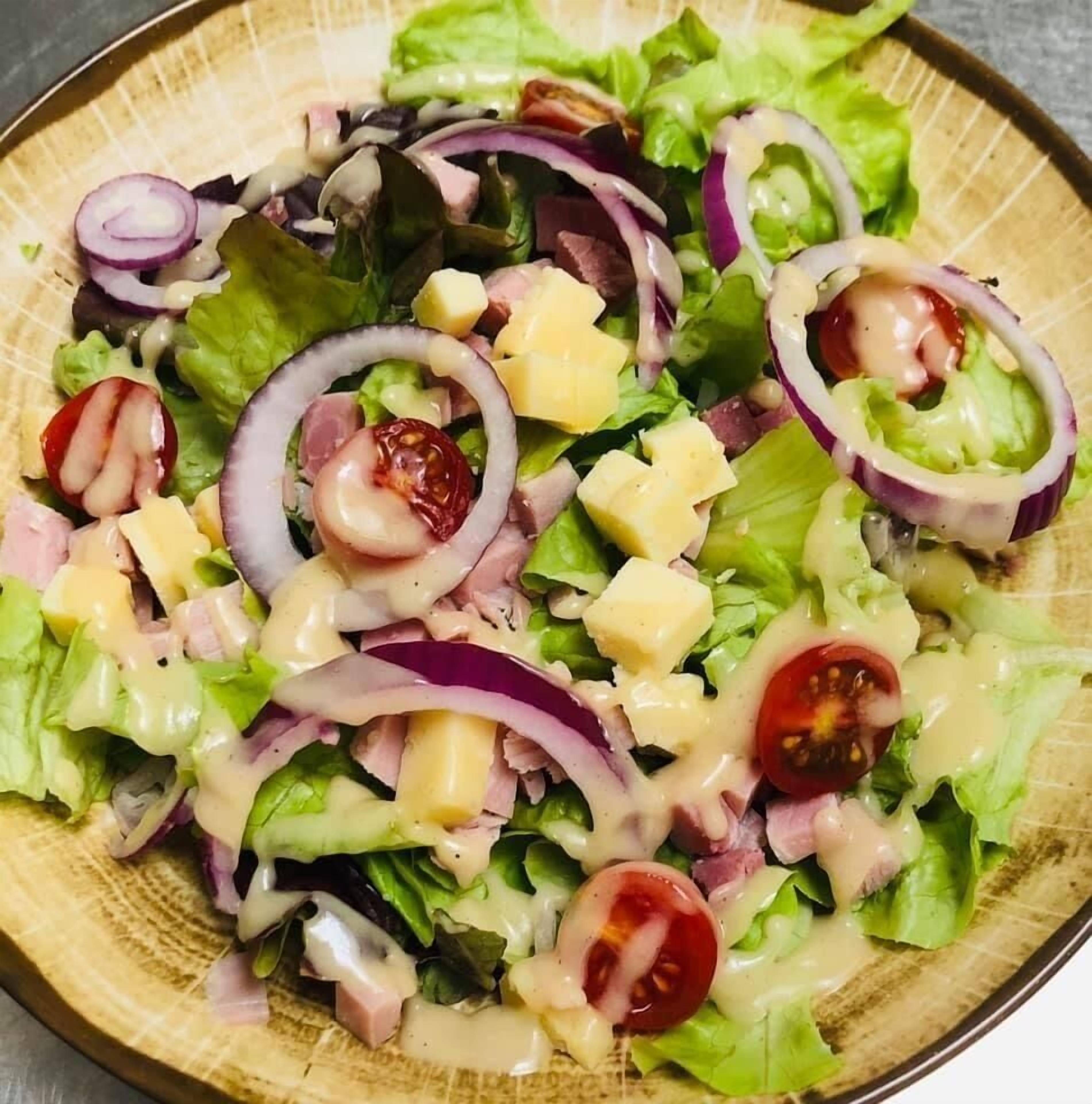 A salad with lettuce, red onions, tomatoes, and cheese.