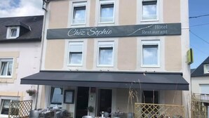 Un hotel llamado Chez Sophie Restaurant con terraza al aire libre y un patio cubierto.