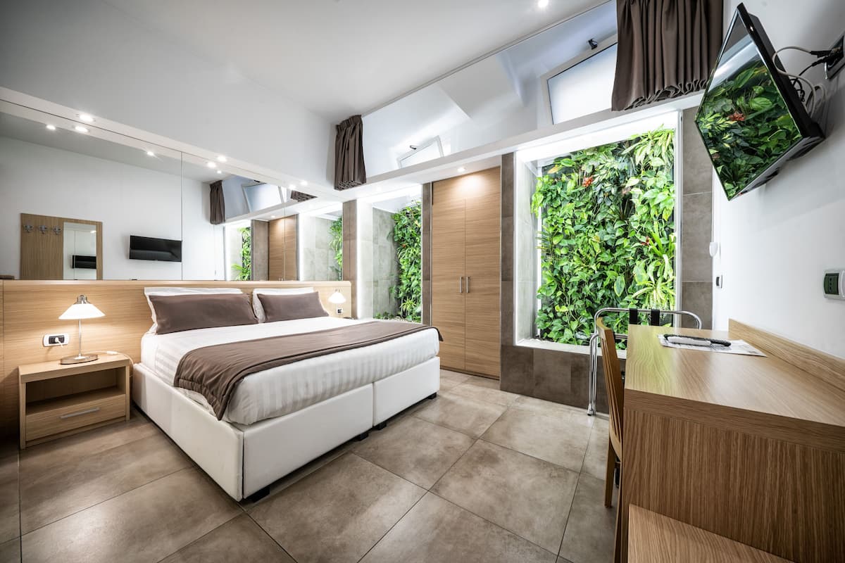 Une chambre moderne avec un grand lit, des tables de chevet, un bureau et un téléviseur.