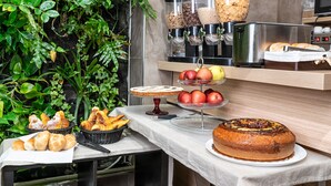 Een ontbijtbuffet met diverse gerechten, zoals gebak, fruit en een taart.
