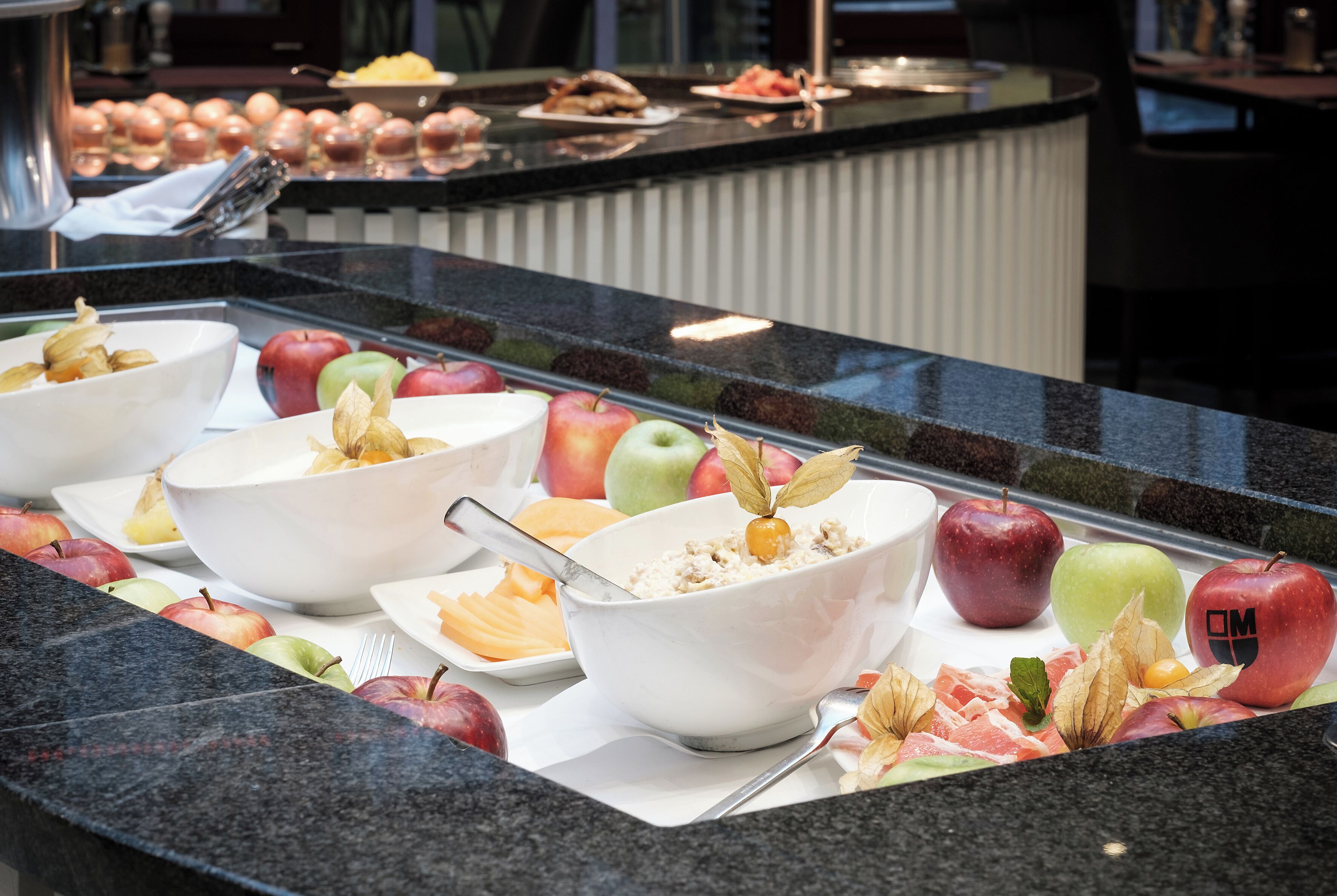 Ein Buffet mit verschiedenen Früchten und einer Schüssel Müsli.