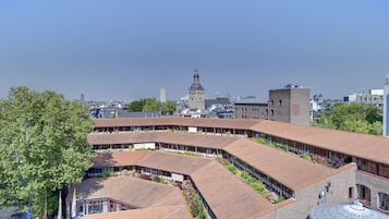 A large building with a curved roofline, multiple windows, and a prominent tower in the background.