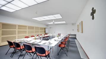 A conference room with a long table, chairs, and a whiteboard.