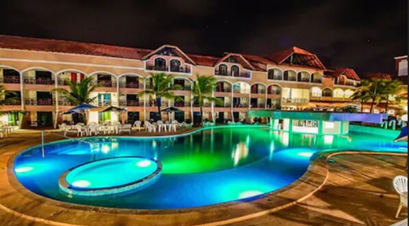 A hotel with a large swimming pool, multiple balconies, and outdoor seating areas. - Hotel Privê do Atalaia (Salinópolis)