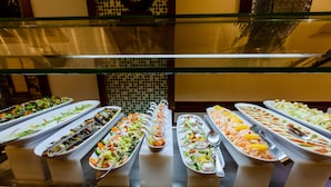 Ein reichhaltiges Buffet mit verschiedenen Speisen, darunter Salate, Früchte und Gemüse.