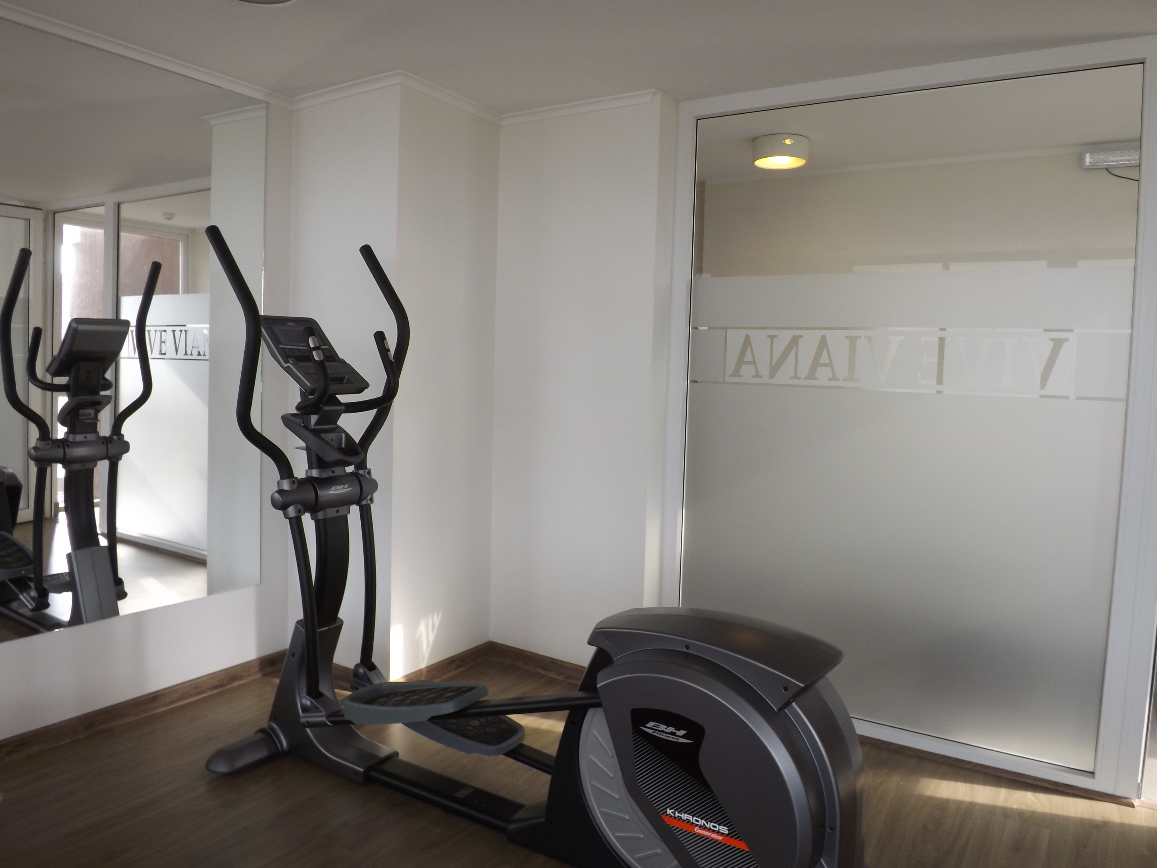 Un gimnasio en casa con una máquina elíptica y una bicicleta estática.