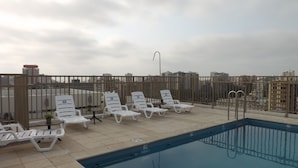 A rooftop pool area with white lounge chairs and a pool. - Edificio Vive Viana I (Vina del Mar)