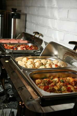 A buffet with various dishes including meat, vegetables, and possibly pasta.