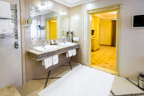 A bathroom with two sinks, a mirror, and a towel rack.