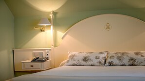 A hotel room with a bed, a nightstand with a telephone, and a wall-mounted lamp. - Hotel Harrison Etxea (Amorebieta)