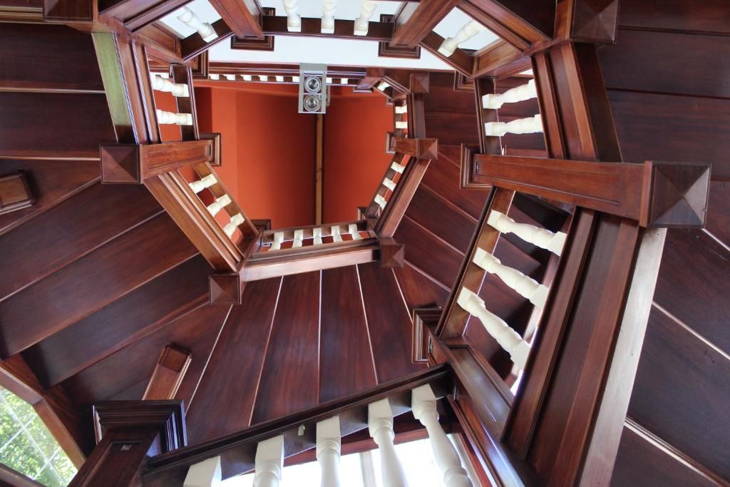 A spiral staircase with wooden railings and a central open space.