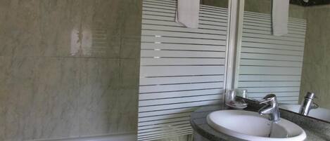 Een badkamer met een wastafel, spiegel en handdoekhouder.