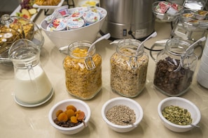 A buffet table with various food items including jars of cereal, nuts, and dried fruits. - Citi Hotel's Wroclaw (Wroclaw)