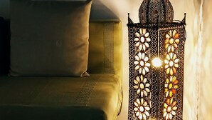 A bed with a pillow and a decorative wall-mounted light fixture.
