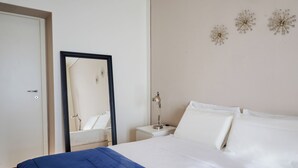 A bedroom with a bed, a nightstand, a mirror, and wall decorations. - Milan Retreats - Porta Venezia (Milan)