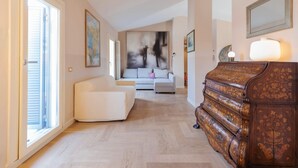 A spacious living room with a white sofa, a wooden cabinet, and a large abstract painting on the wall. - Milan Retreats - Porta Venezia (Milan)