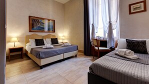 A hotel room with two beds, a desk, and a painting on the wall. - AmoRoma (Rome)