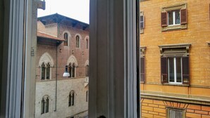 A view through a window of a building with arched windows and a brick facade. - AmoRoma (Rome)