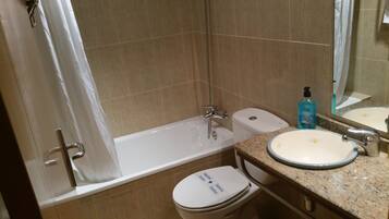 Un baño con bañera, inodoro y lavamanos.