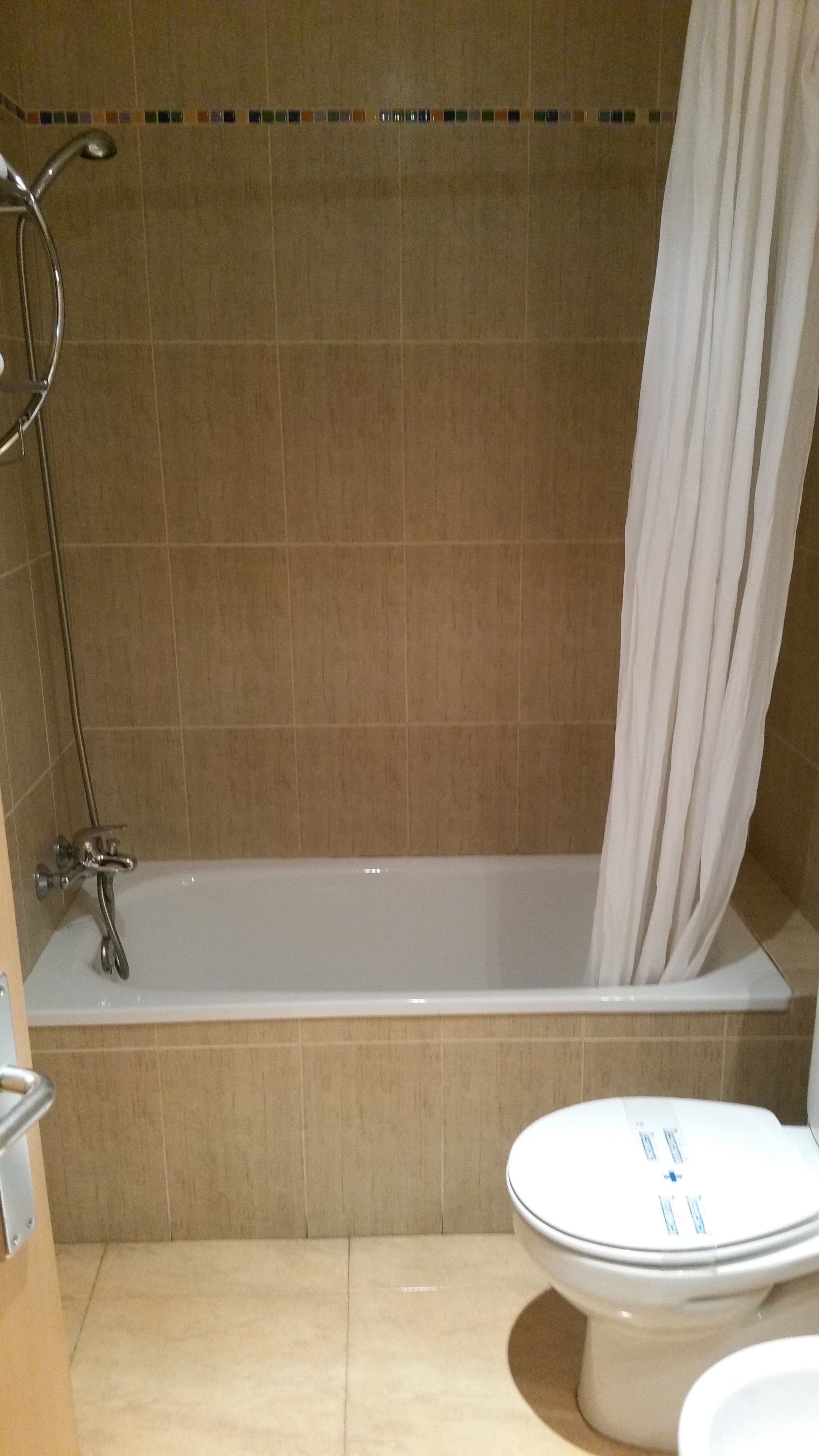 Un baño con bañera, ducha e inodoro.