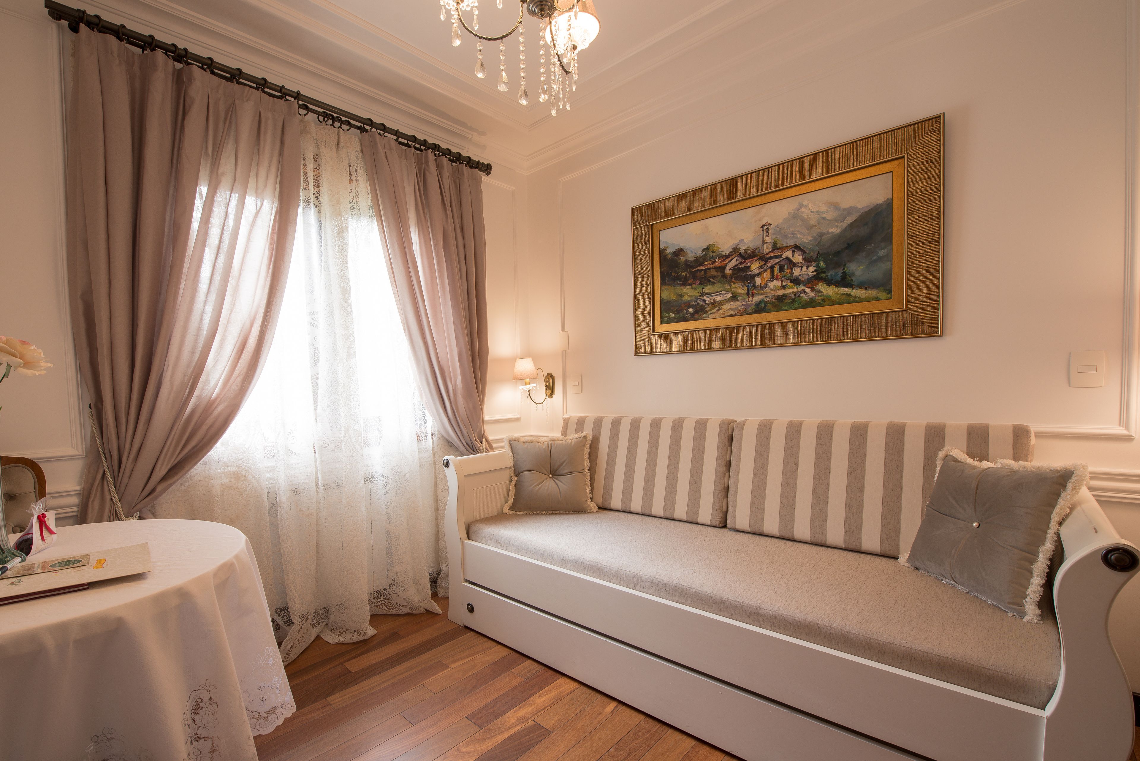 Una habitación acogedora con sofá, un cuadro y una mesa con lámpara.