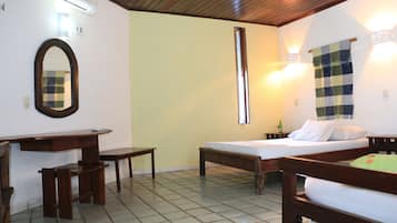 Quarto com cama, escrivaninha e espelho.