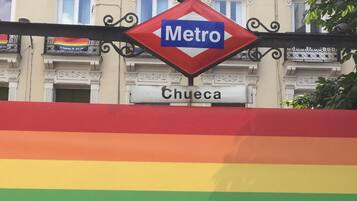 A Metro sign above a building with a rainbow flag.