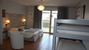 A modern bedroom with a bed, bedside lamps, a white chair, a bunk bed, and a view through a glass door.