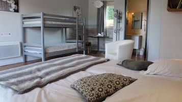 A bedroom with bunk beds, a desk, a chair, and a bathroom visible through an open door.