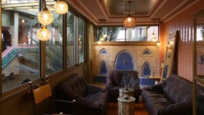 A room with leather sofas, a patterned coffee table, and hanging spherical light fixtures. - Riad Atlas Quatre & Spa (Marrakech)