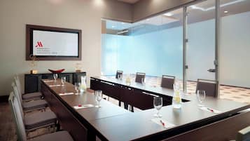 A conference room with a long table, chairs, and a screen displaying the Marriott Columbus University Area logo.