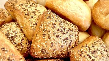 Ein Korb mit verschiedenen Brotsorten, darunter einige mit Saaten belegt.