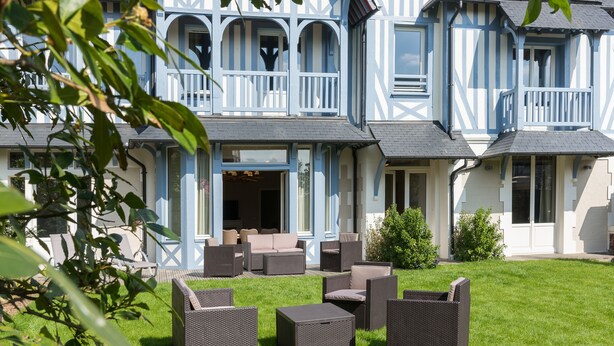 Una casa grande con balcón y zona de estar al aire libre.