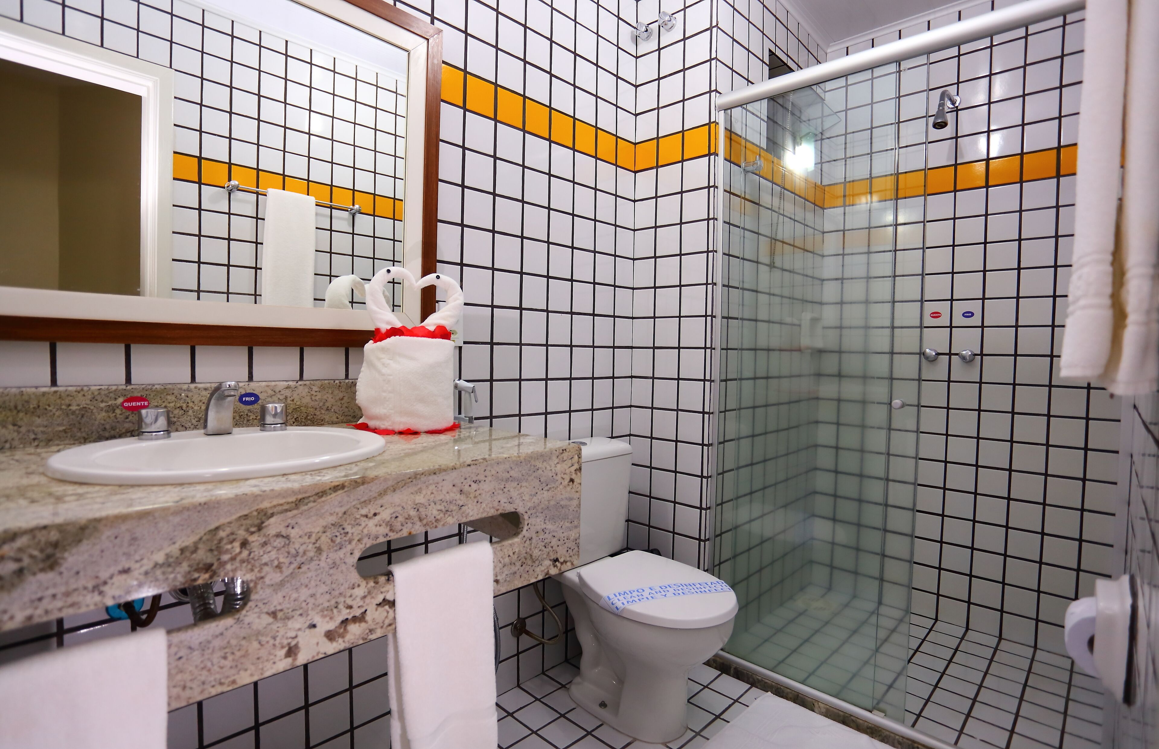 Une salle de bain équipée d’un lavabo, de toilettes et d’une douche à parois de verre.