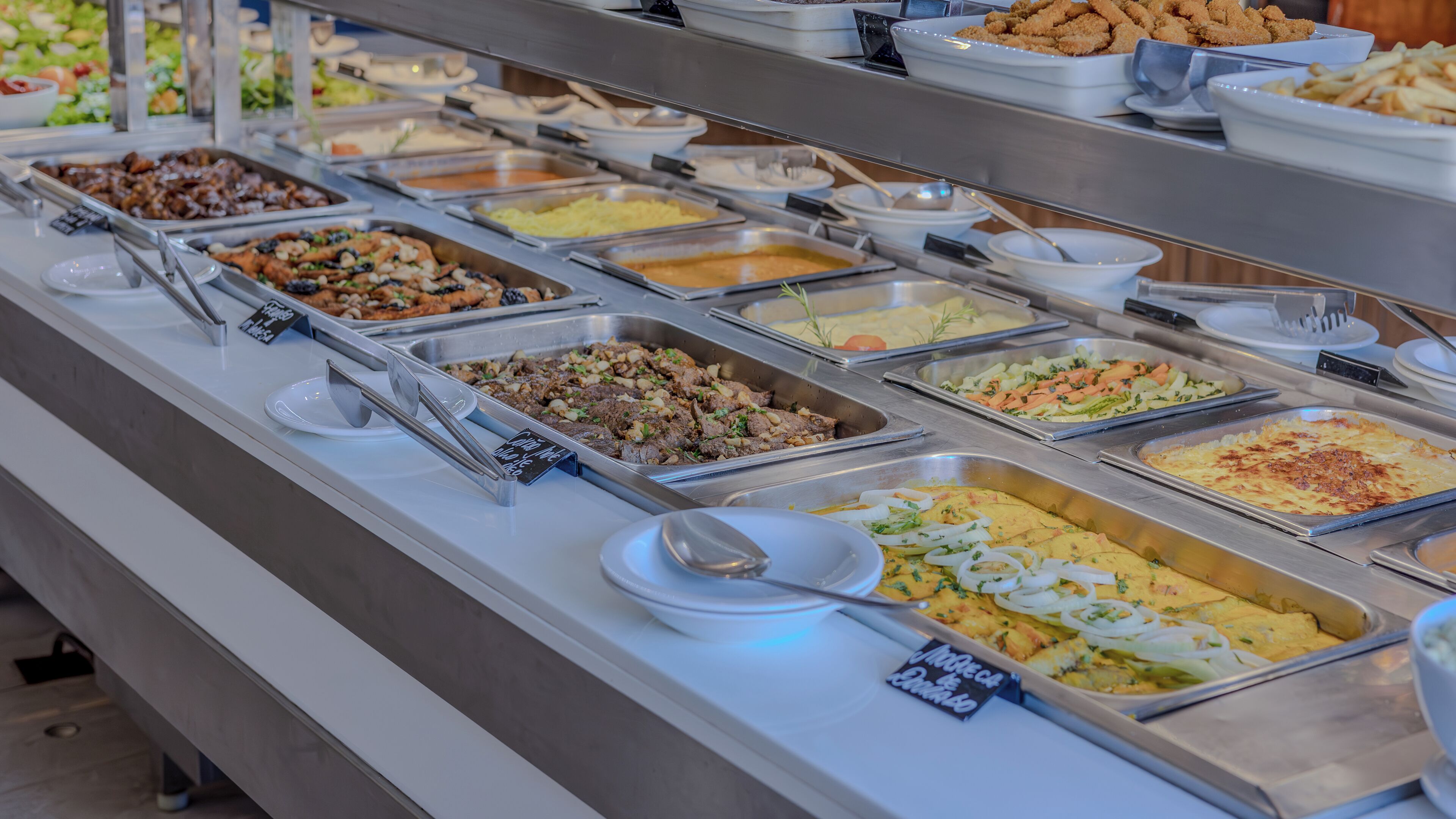 A buffet with various food options including meats, salads, and other dishes.