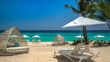 On the beach, white sand, sun-loungers, beach towels