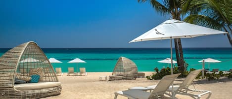 On the beach, white sand, sun-loungers, beach towels