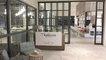 Un interno di ristorante moderno con un cartello che riporta la scritta "Thalassa Restaurante Tao Cuisine".