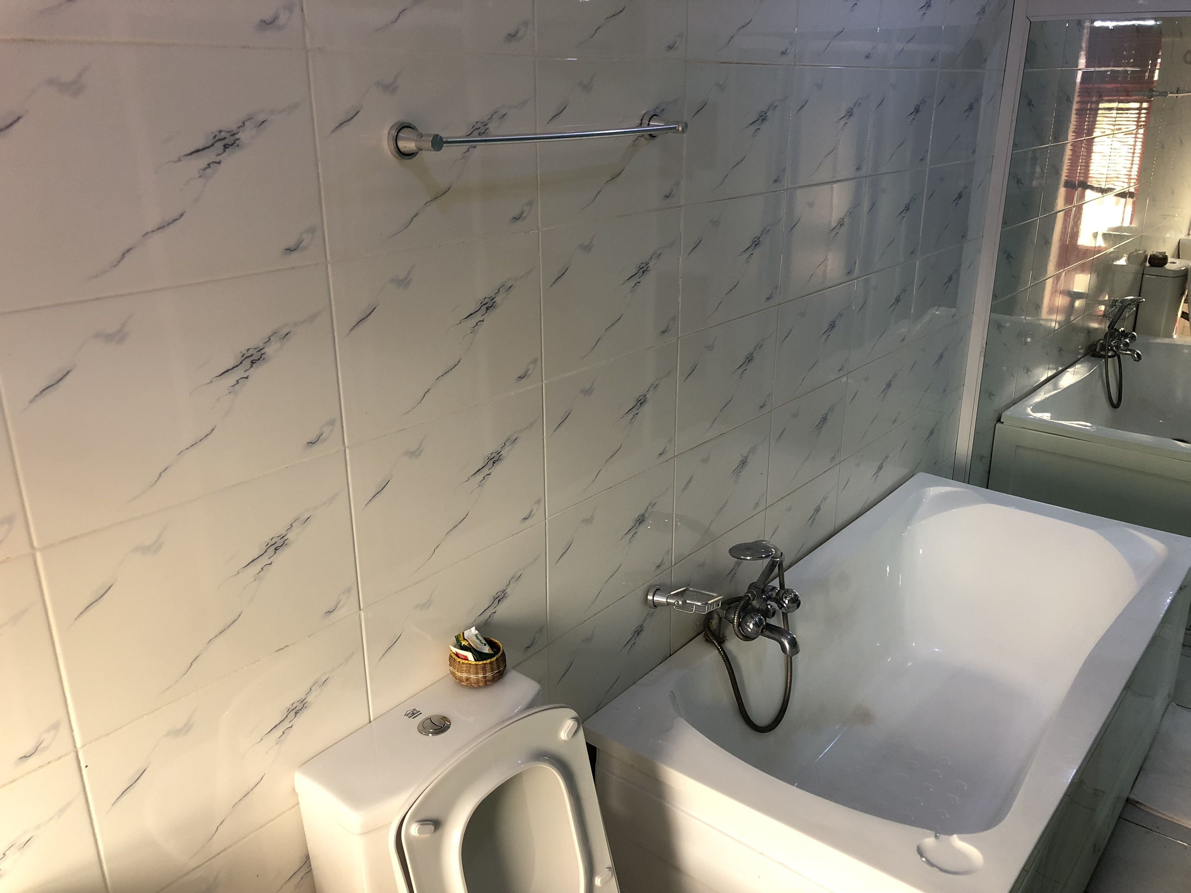 A bathroom with a white bathtub, a toilet, and a bidet.