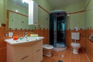 A bathroom with a sink, bidet, toilet, and a glass-enclosed shower area. - Villa in Croatia with Pool near Beach (Dramalj)