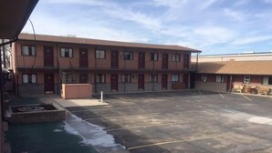 A parking lot with a building in the background. - Park Motel (North Platte)