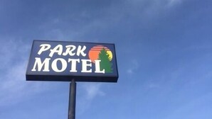 A sign for a Park Motel with a logo featuring a tree and a sun. - Park Motel (North Platte)