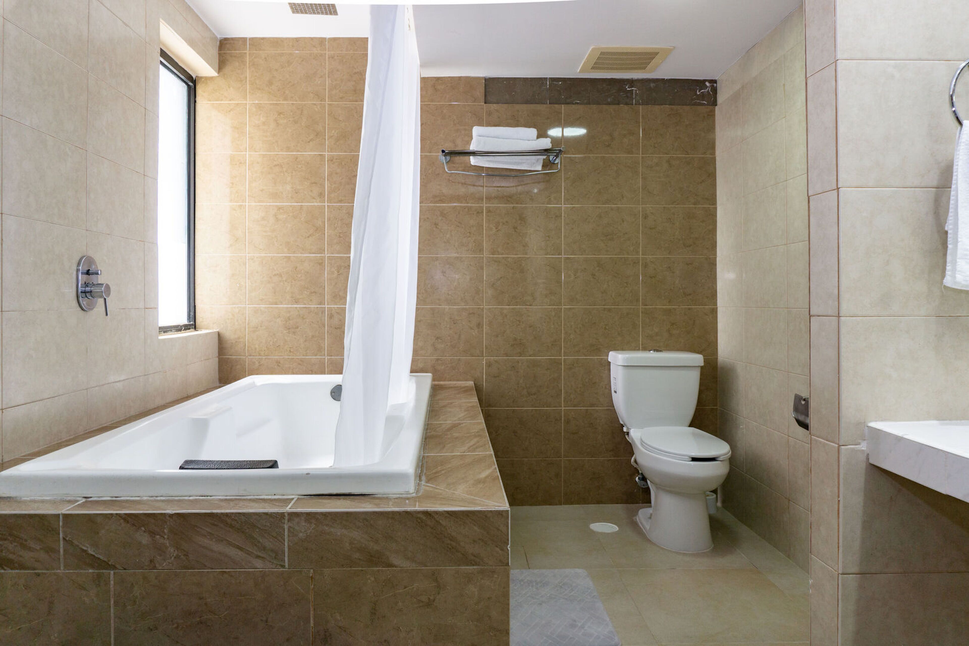 Ein modernes Badezimmer mit Badewanne, Toilette und Handtuchhalter.