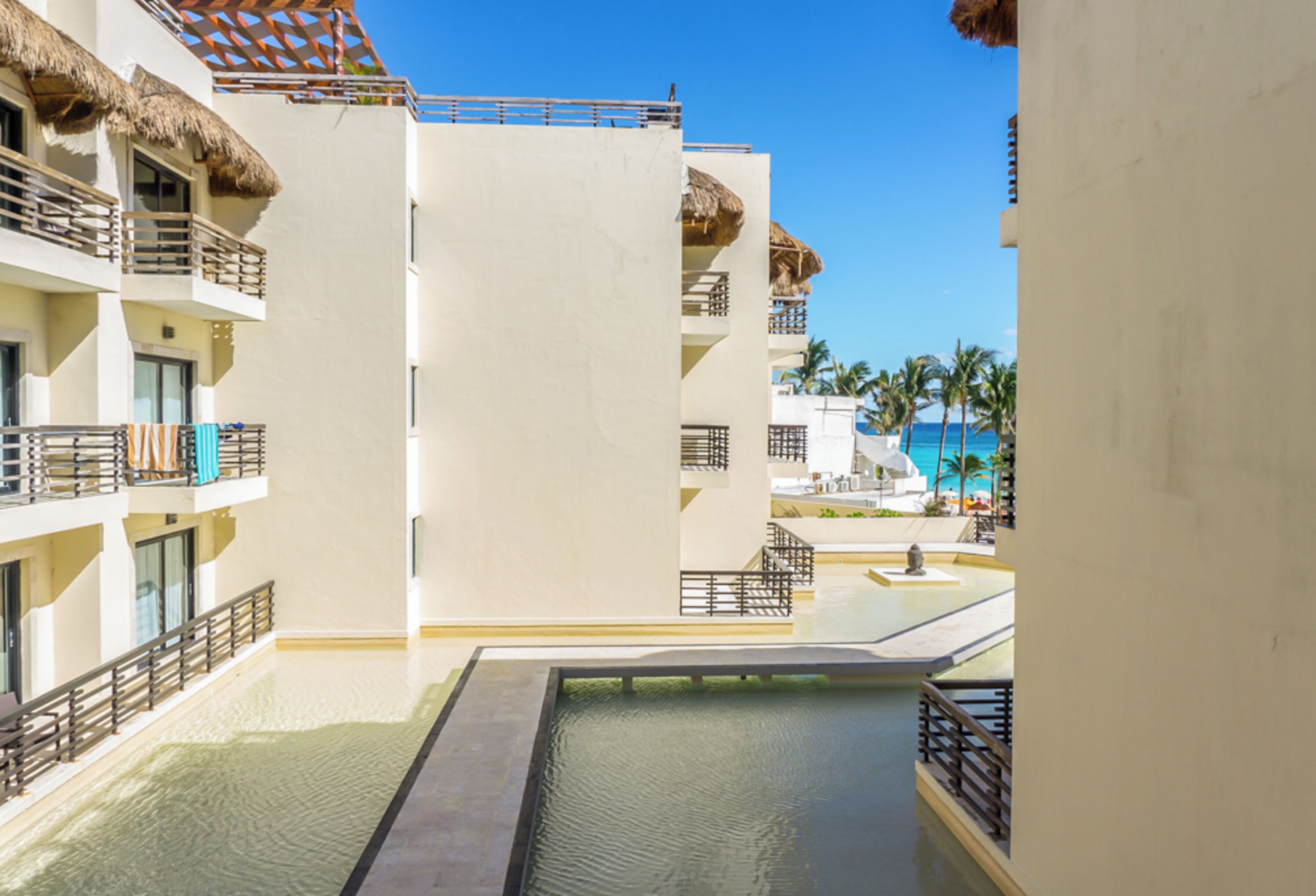 Un resort con diversi balconi, una piscina e vista sull'oceano.
