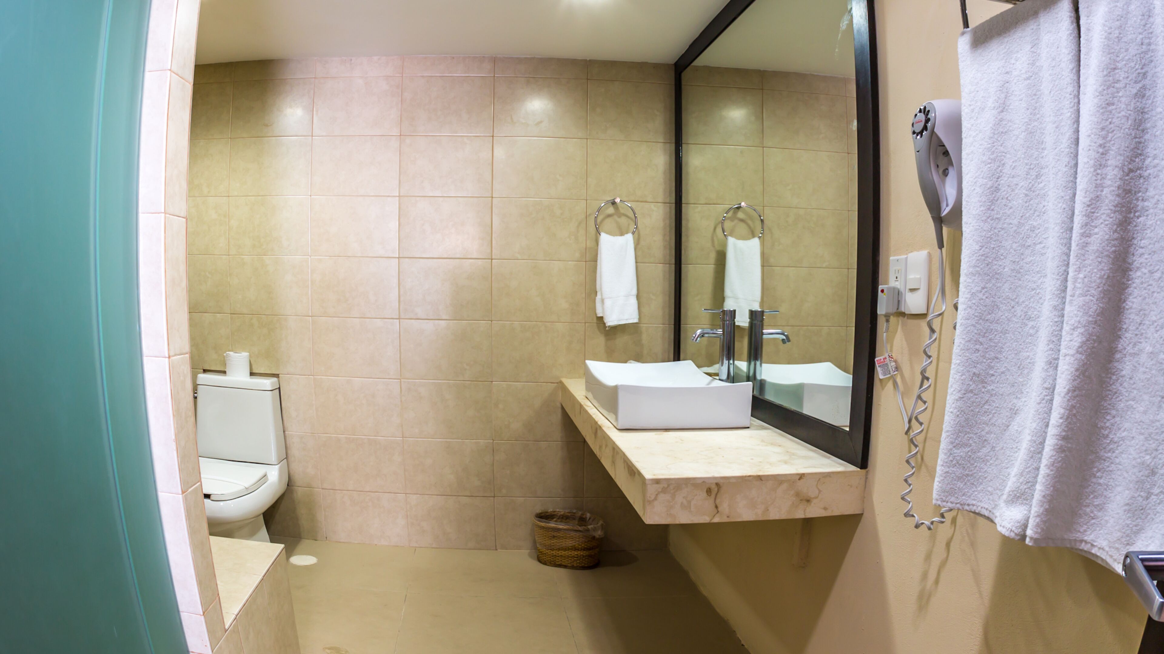 Une salle de bain avec des toilettes, un lavabo et un miroir.