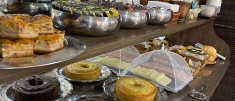 A buffet with various baked goods and desserts.