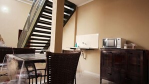 A dining area with a staircase, a microwave, and a cabinet.