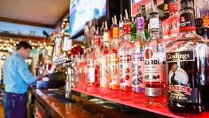 Eine Bar mit einer Auswahl an Spirituosenflaschen in Regalen.